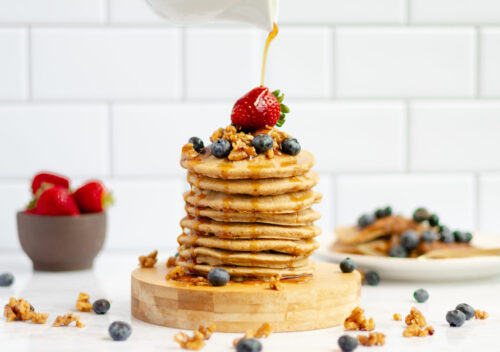 Pouring thick, golden buttermilk syrup made with dates onto pancakes