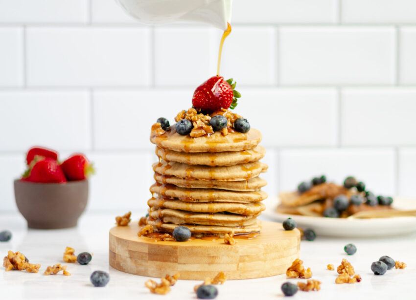 Pouring thick, golden buttermilk syrup made with dates onto pancakes