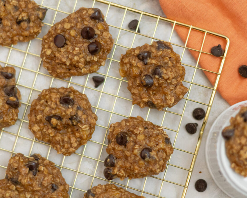Soft-baked banana chocolate chip oatmeal cookies on a cooling rack, made with wholesome ingredients like banana, oats, and no-sugar-added chocolate chips — gluten-free and refined sugar-free.